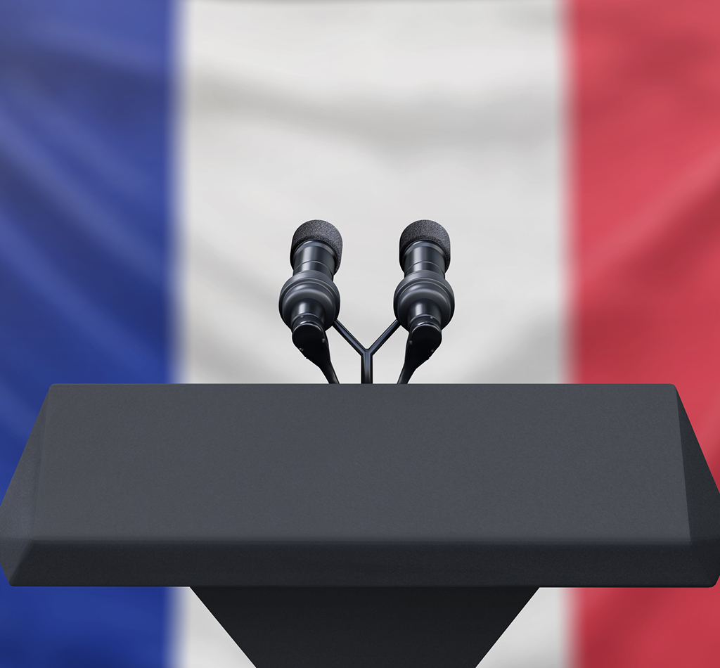 Podium lectern with two microphones and French flag in background