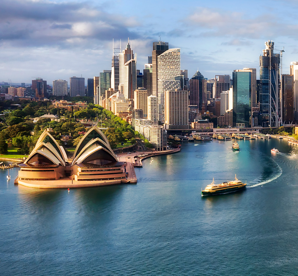 Waterfront architectural landmarks of Sydney Harbour in aerial cityscape.