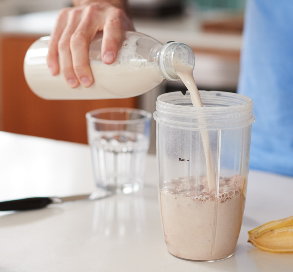 Close up of person making a protein shake at home.